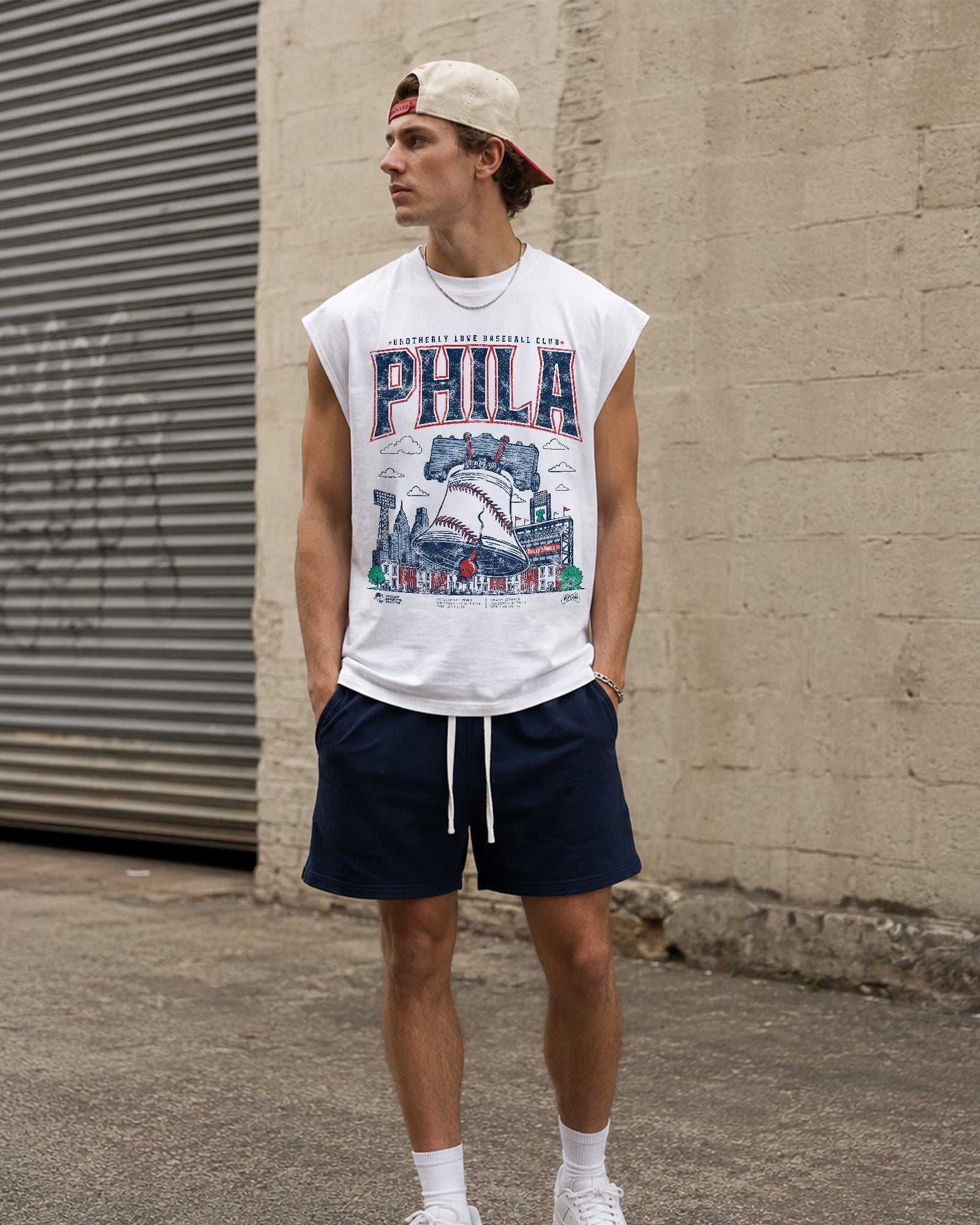 A man wearing a white sleeveless Phillies shirt.